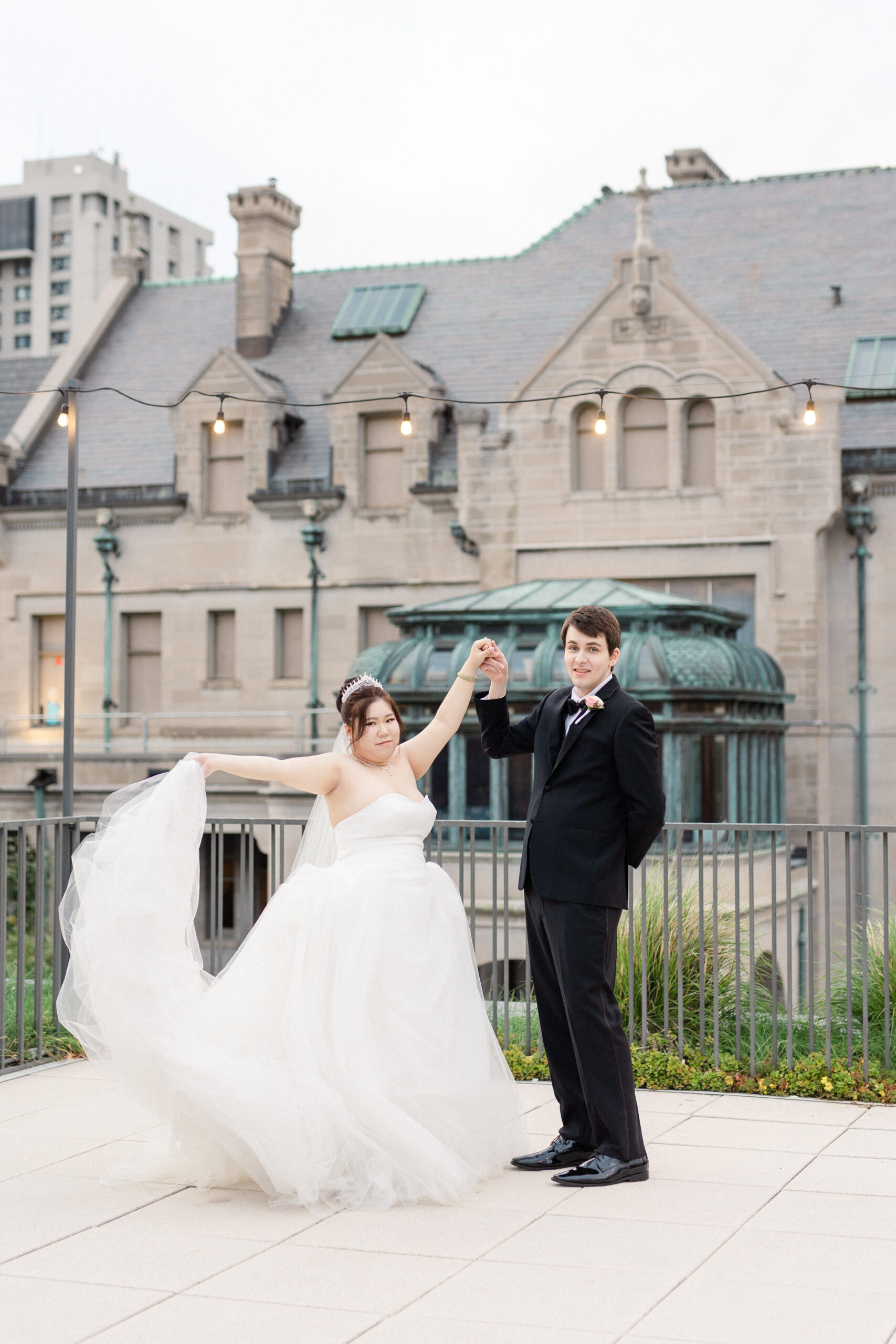 Bride and groom dancing on a rooftop at sunset on their wedding day.