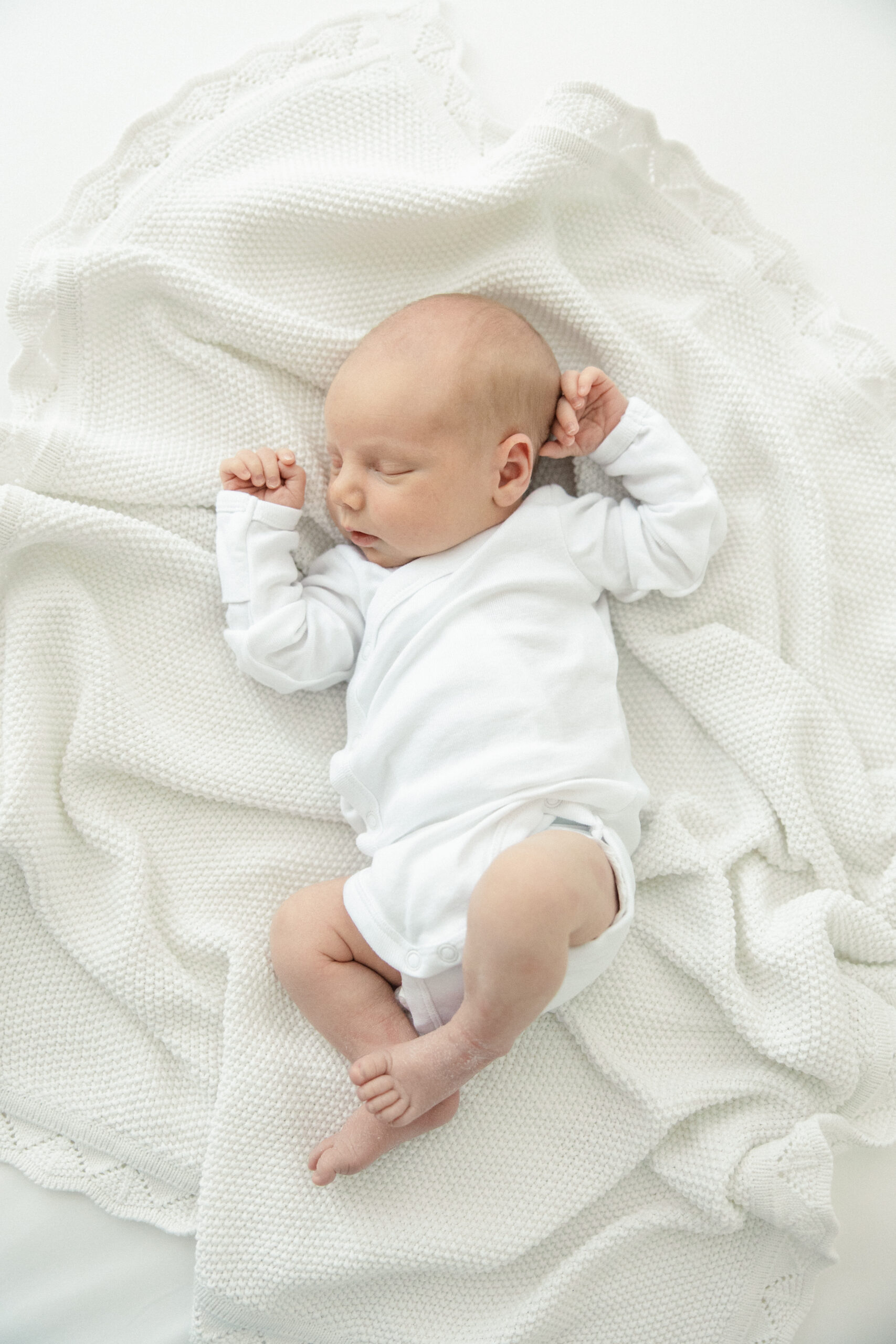 Sleepy newborn session in an all white studio.